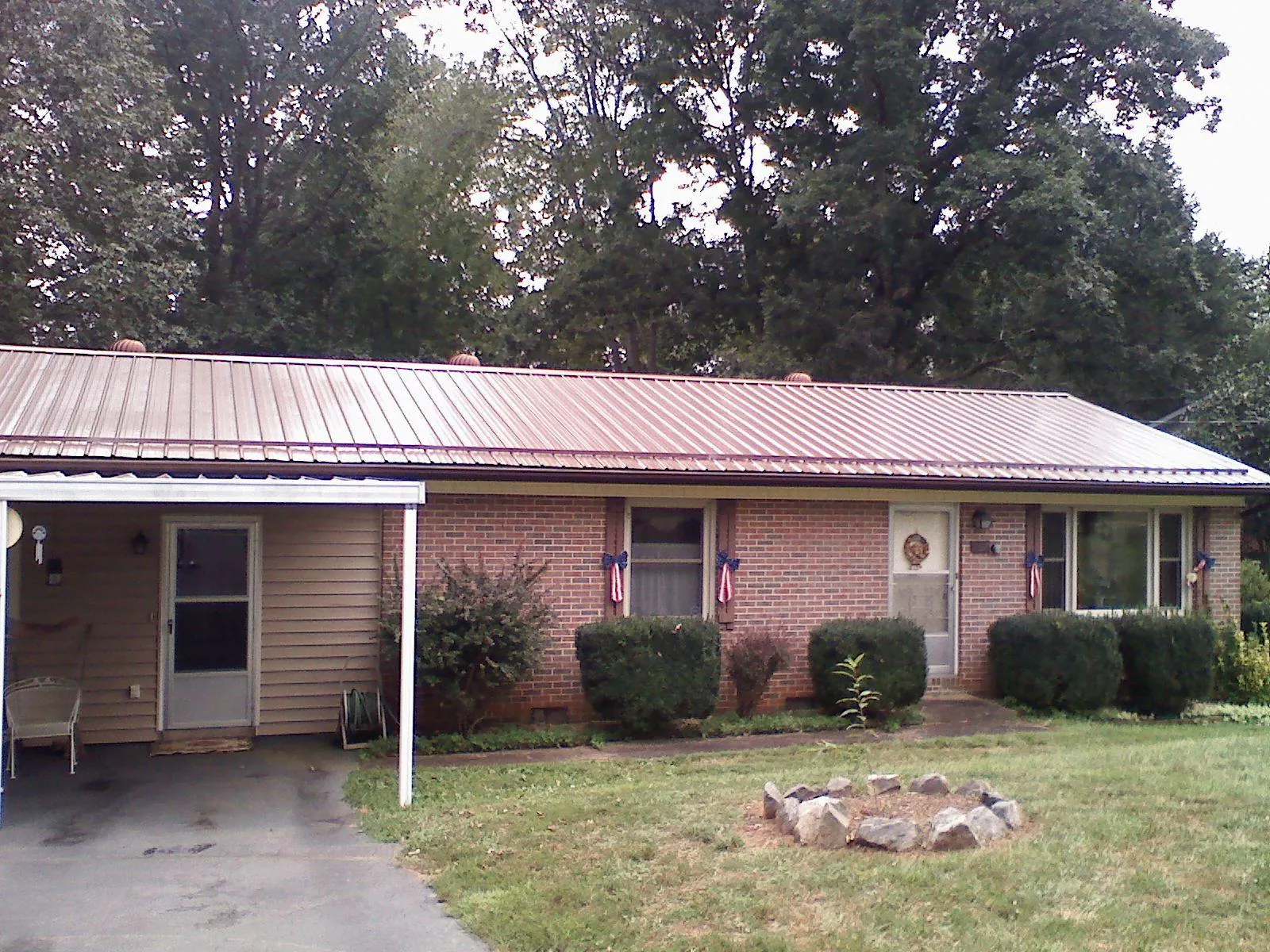 Bronze metal roof and carport on a brick ranch home — Roof Repair work by our crew in Rockton