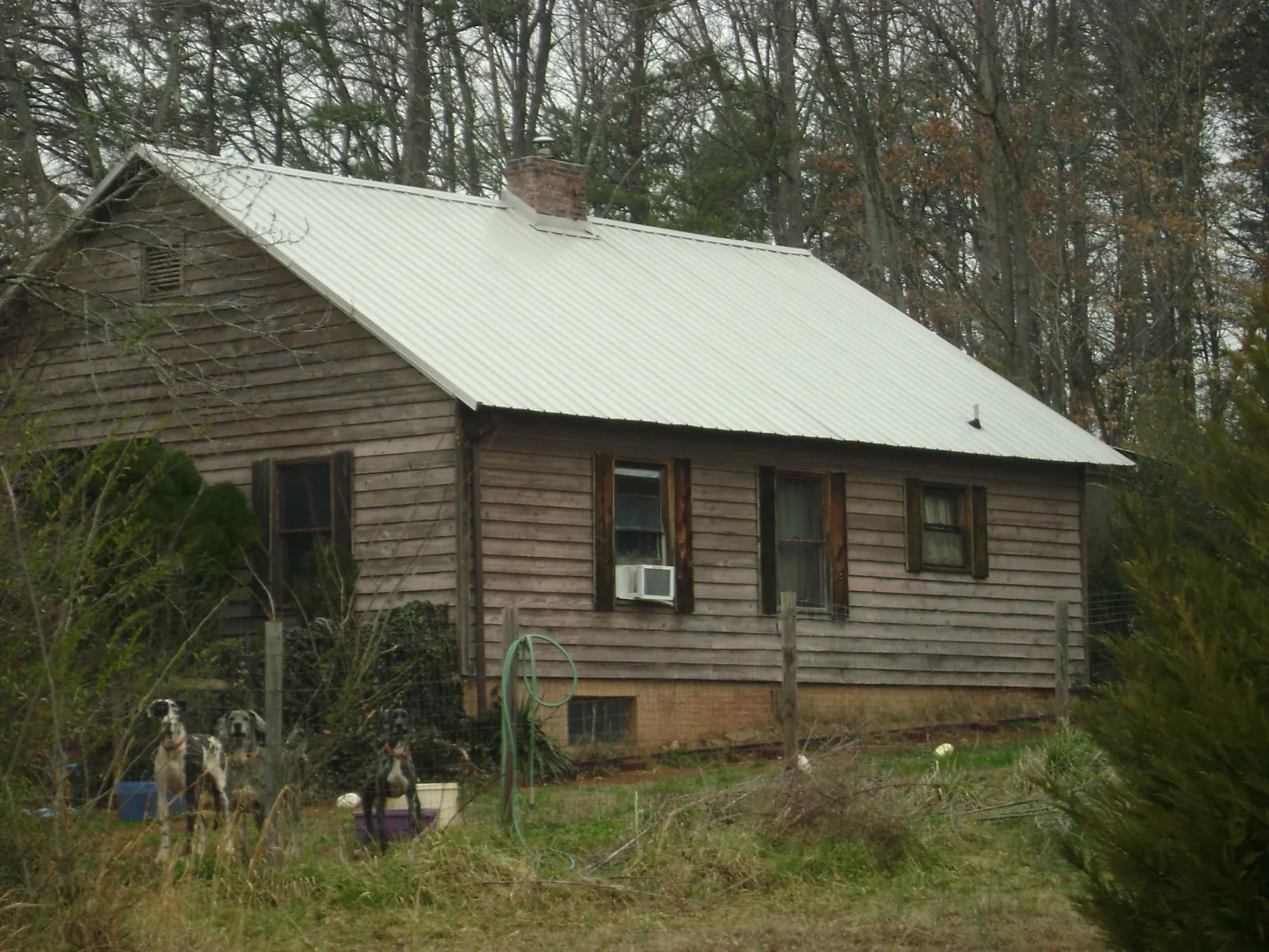 White metal roof on an old wood sided farmhouse, from a Metal Roof Installation job in Rockton
